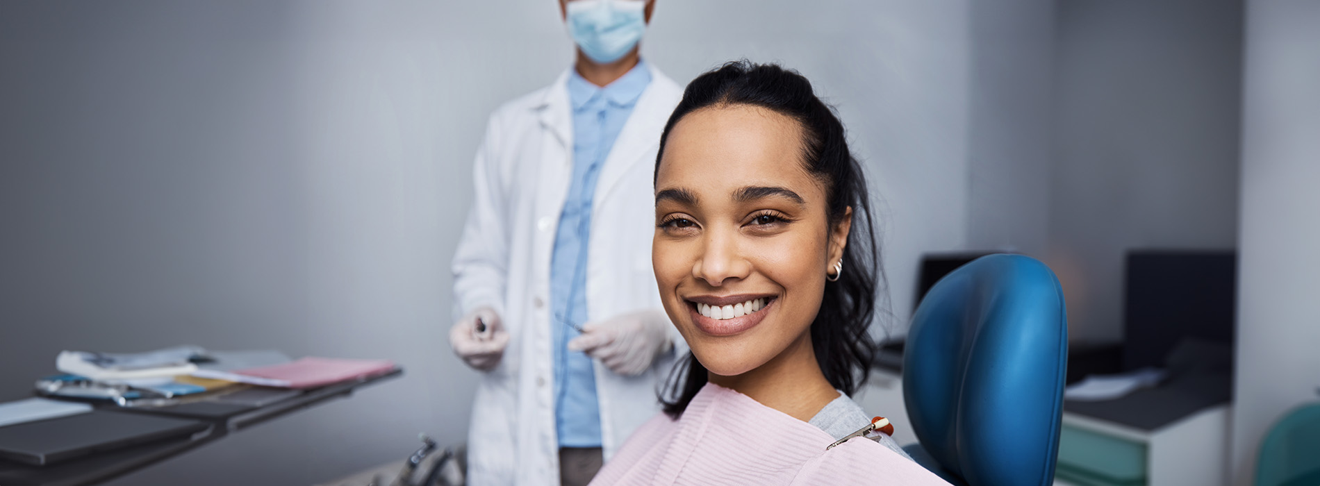 A well-lit reception area with a desk, computer monitor, and potted plant.